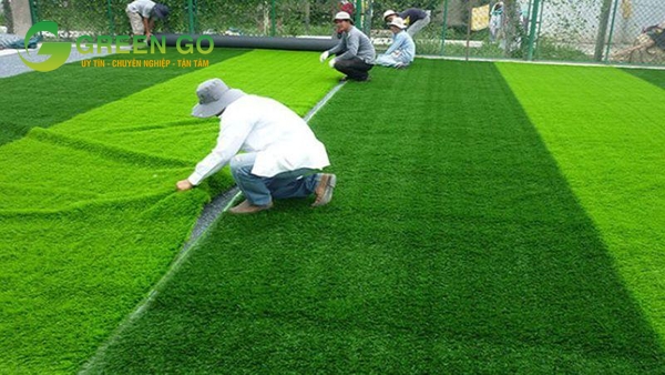 Trải từng cuộn cỏ nhân tạo mới lên mặt sân